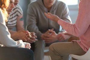 a group of people discussing during addiction group therapy