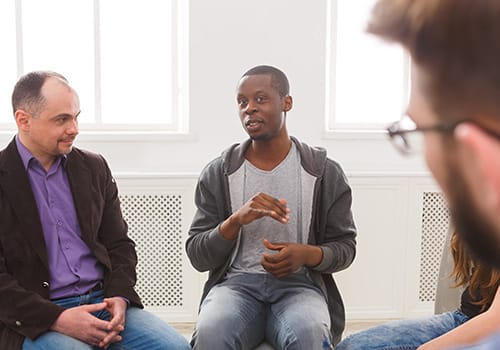 a group talks during drug rehab for men