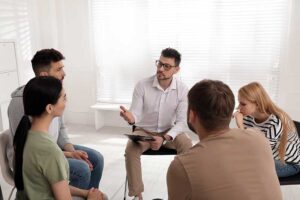 men and women sitting in a circle and enjoying the benefits of group therapy.