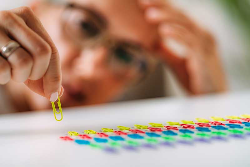 close up of person sorting paper clips by size and color as an example of understanding OCD