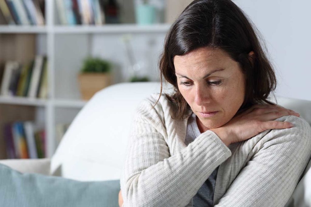woman sitting on couch struggling with emotional instability