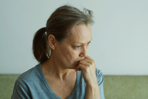 middle-aged woman looking pensive and disturbed as she considers how does alcohol interact with SSRIs?