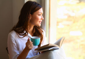 woman reads and drinks coffee