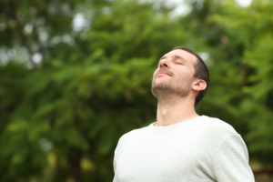 man practices breathing exercises