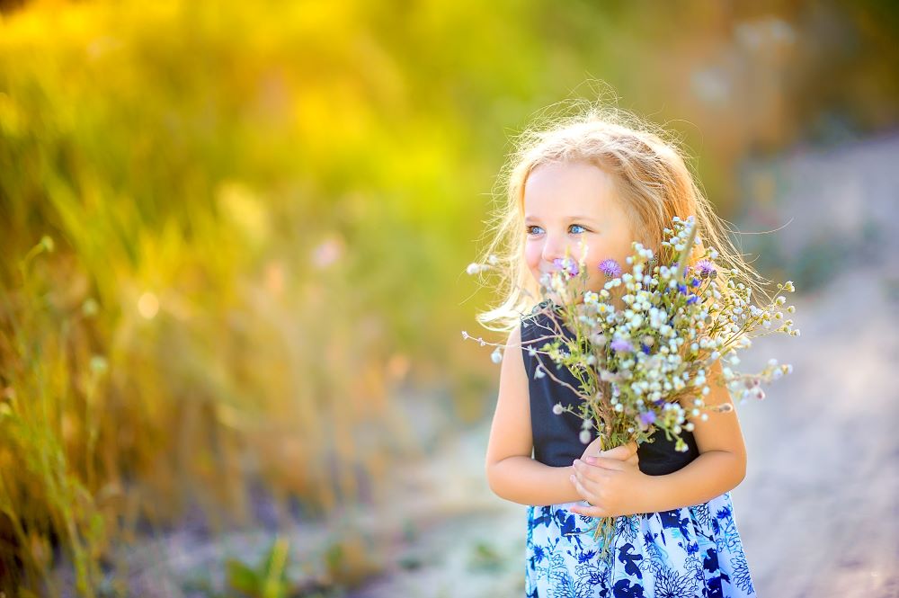 young girl gathers flowers