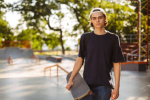 young man poses with skateboard