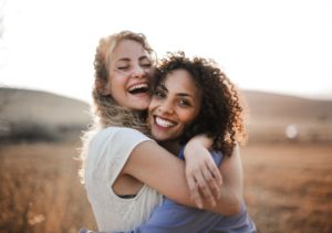 two women embrace in nature