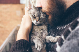 man relaxes with therapy cat