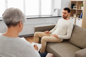 man discusses adverse childhood experiences with therapist