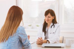 woman discusses medication with doctor