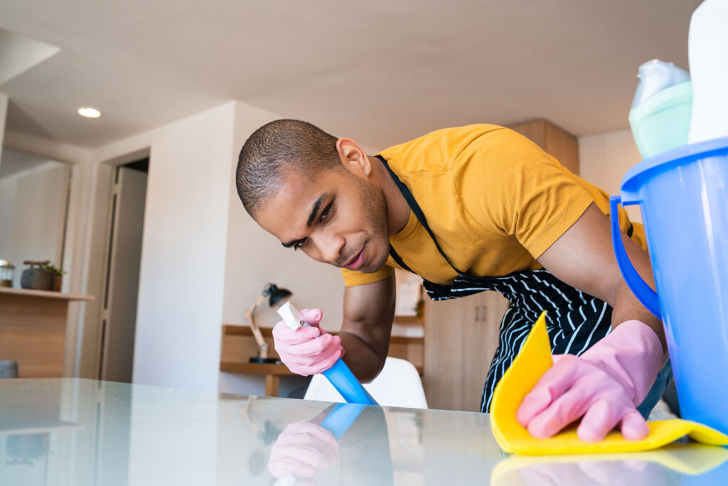 young man in the process of cleaning his apartment as part of using life skills beyond addiction treatment