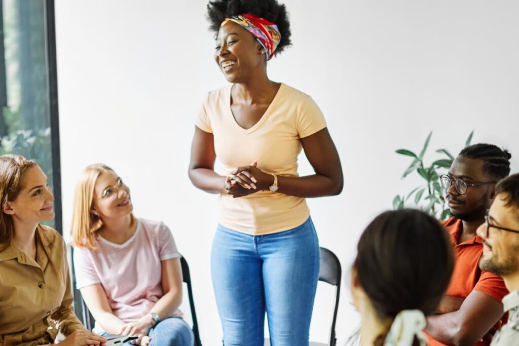 young woman standing and telling her story at a group therapy activity for adults in recovery