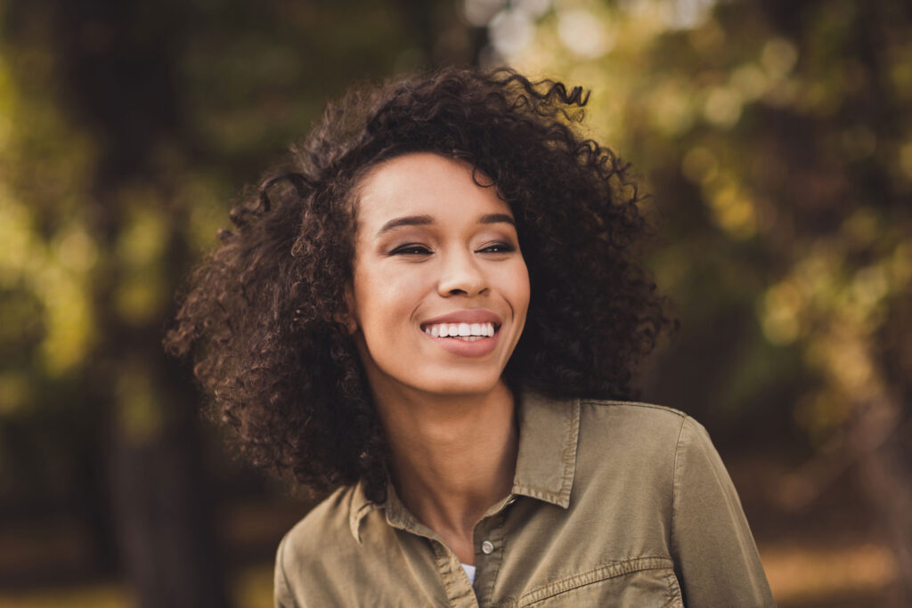 smiling young woman enjoying the outdoors after asking "is a sober living program right for me?"
