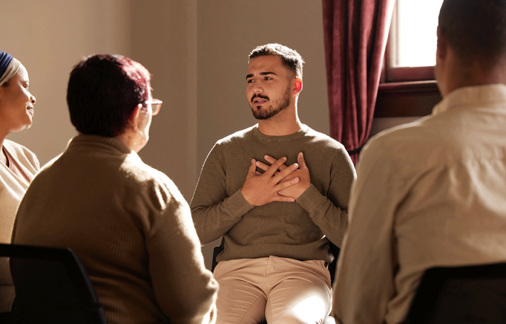 young man in group session for addiction treatment explaining strategies for coping with co-occurring disorders