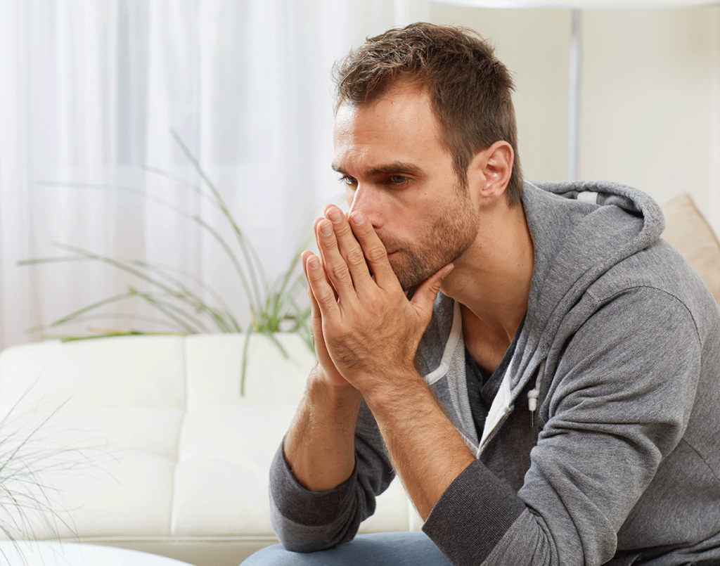 young man seated on couch in addiction treatment session discussing ways of identifying relapse triggers