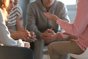 individuals taking part in a group discussion as part of a sober living program