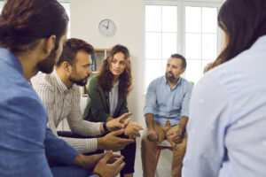 therapist talking to a group of adults about choosing a residential treatment cente in Austin, TX for addiction treatment