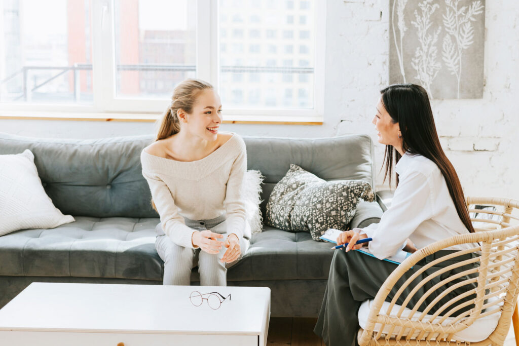 behavioral health specialist talking to a young woman in an office setting about finding trauma therapy in Georgetown, TX