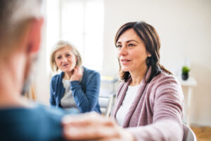 group of adults participating in an intensive outpatient program for addiction treatment and seated in a well-lit, pleasant room