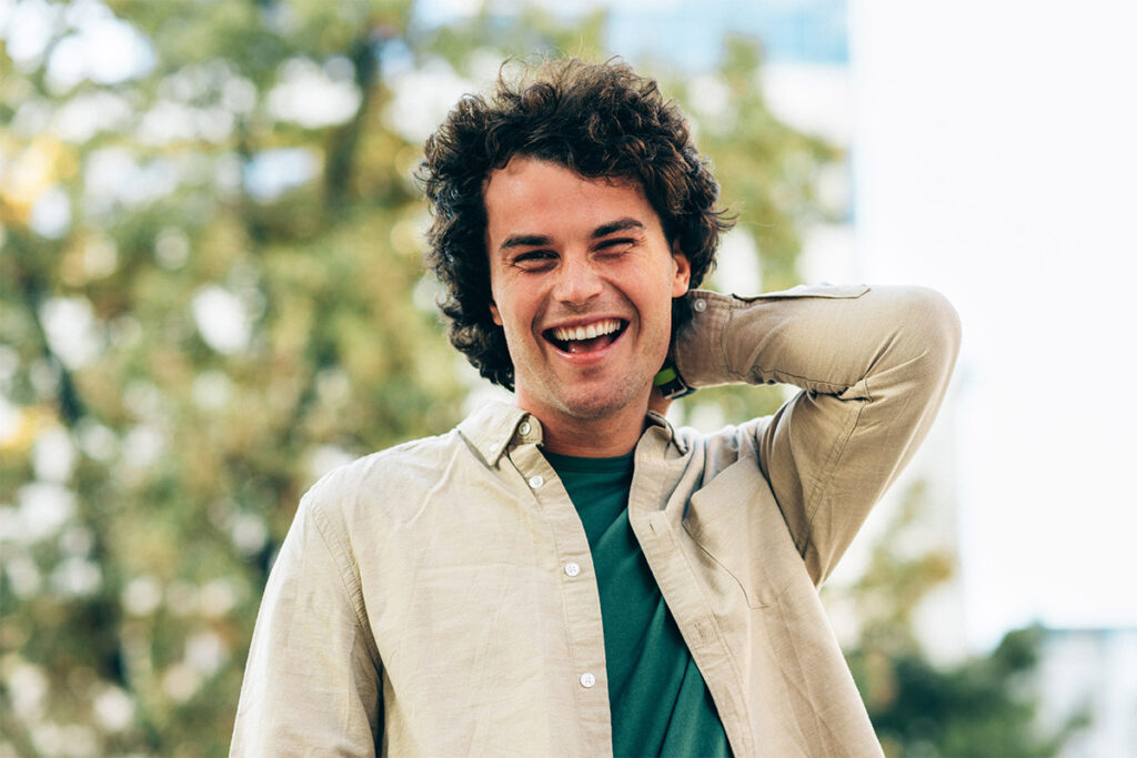 smiling young man enjoying the outdoors after discovering the link between stimulants and bipolar disorder and what you should know