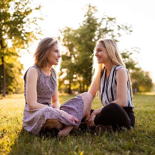 two women speak while in park
